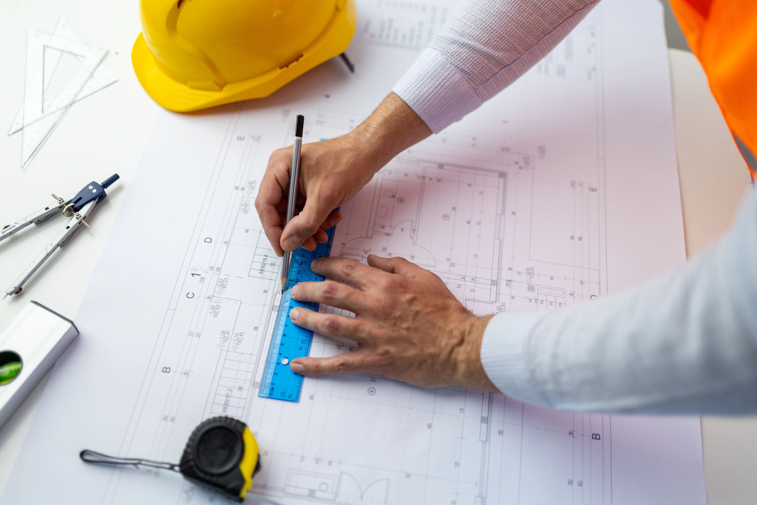 Engineer drawing building plan with ruler